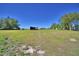 Over View of property, featuring open land, a shed, and a house in the distance under a clear blue sky at 990 Brooke Rd, Fort Meade, FL 33841