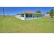 Exterior rear view of home showcasing the screened lanai and green surroundings at 990 Brooke Rd, Fort Meade, FL 33841