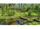 Tranquil waterway featuring vibrant greenery, a small bridge, and reflections of the blue sky at 990 Brooke Rd, Fort Meade, FL 33841