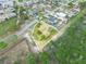 Aerial view showing the house with screened pool, adjacent wooded area, and surrounding neighborhood at 100 Heatherwood Blvd, Lake Wales, FL 33859