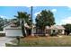 Charming single-story home featuring an attached garage, well-maintained lawn, and mature landscaping, creating curb appeal at 100 Heatherwood Blvd, Lake Wales, FL 33859