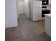 The kitchen entrance shows tiled flooring, a refrigerator, microwave, and oven along a white wall at 100 Heatherwood Blvd, Lake Wales, FL 33859