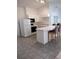 Bright kitchen featuring white cabinetry, appliances, and a tiled floor with a breakfast bar seating two at 100 Heatherwood Blvd, Lake Wales, FL 33859