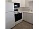 View of the kitchen with white LG refrigerator, black microwave, oven, and tiled floor at 100 Heatherwood Blvd, Lake Wales, FL 33859