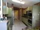 Long kitchen with stainless steel appliances, tile flooring, and decorative wallpaper at 100 Heatherwood Blvd, Lake Wales, FL 33859