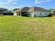 Large backyard with lush green grass and a covered patio, perfect for outdoor gatherings and relaxation at 1055 Lena Run Ct, Winter Haven, FL 33880