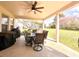 Inviting covered patio features an outdoor dining set, ceiling fan, and a view of the landscaped backyard at 1055 Lena Run Ct, Winter Haven, FL 33880