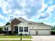 Charming one-story home featuring a manicured lawn, brick accents, a two-car garage, and a welcoming front entrance at 1055 Lena Run Ct, Winter Haven, FL 33880