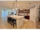 Spacious kitchen with a white island, dark cabinetry, pendant lighting, and neutral tile flooring at 1055 Lena Run Ct, Winter Haven, FL 33880