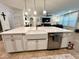 Kitchen island with white cabinets, a farmhouse sink, and stainless steel dishwasher, perfect for entertaining at 1055 Lena Run Ct, Winter Haven, FL 33880
