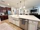 Kitchen island with white cabinets, a farmhouse sink, and stainless steel dishwasher, open to the living room at 1055 Lena Run Ct, Winter Haven, FL 33880
