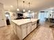 Kitchen island with a farmhouse sink, stainless steel dishwasher, seating and is open to the living and dining areas at 1055 Lena Run Ct, Winter Haven, FL 33880