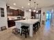 Kitchen featuring a large island with seating, stainless steel appliances, and dark wood cabinets at 1055 Lena Run Ct, Winter Haven, FL 33880