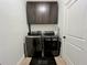 Functional laundry room features modern appliances, upper cabinets, and tile flooring for easy cleaning at 1055 Lena Run Ct, Winter Haven, FL 33880