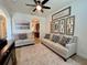 Open-concept living room featuring neutral sofas, accent mirrors, and a modern ceiling fan at 1055 Lena Run Ct, Winter Haven, FL 33880