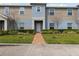 Charming townhome showcasing manicured lawn, blue and beige exterior, and welcoming brick walkway to front door at 141 Claire Ln, Davenport, FL 33837