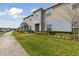 Charming two-story townhome featuring landscaped front yard at 141 Claire Ln, Davenport, FL 33837