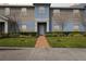 Attractive townhome with a lush green lawn, manicured bushes, and tidy landscaping at 141 Claire Ln, Davenport, FL 33837