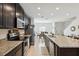 Open kitchen featuring granite countertops, stainless steel appliances, and dark wood cabinetry at 141 Claire Ln, Davenport, FL 33837