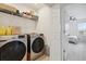 Convenient laundry room with modern washer and dryer units, and shelf for storage at 141 Claire Ln, Davenport, FL 33837