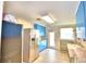 Galley-style kitchen featuring blue cabinets, stainless steel appliances, and tile flooring at 1475 S Lake Howard Dr, Winter Haven, FL 33880
