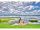 Scenic lake view featuring a wooden dock, lush greenery, and serene water under a cloudy sky at 1475 S Lake Howard Dr, Winter Haven, FL 33880