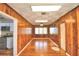 Wood-paneled living room with hardwood floors, neutral paint colors and a view into the open kitchen at 1475 S Lake Howard Dr, Winter Haven, FL 33880