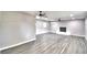 Open concept living room with laminate floors, fireplace, and ceiling fans at 1475 S Lake Howard Dr, Winter Haven, FL 33880