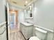 Well-lit bathroom features a toilet, sink, vanity with storage, and a mirror at 1819 4Th Se Ct, Winter Haven, FL 33880