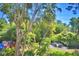Private backyard with mature trees, lush landscaping, and peaceful fountain at 200 El Camino Dr # 202, Winter Haven, FL 33884