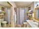 Well-lit bathroom featuring a single sink vanity, decorative mirror, and stylish shower curtain, blending functionality and style at 200 El Camino Dr # 202, Winter Haven, FL 33884