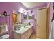 Cozy bathroom featuring a sink, two mirrors, and colorful purple walls at 200 El Camino Dr # 202, Winter Haven, FL 33884
