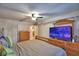 Bedroom with a television, wood floors, and a ceiling fan at 200 El Camino Dr # 202, Winter Haven, FL 33884