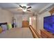 A well-lit bedroom featuring a ceiling fan, closet, and a glimpse into the bathroom at 200 El Camino Dr # 202, Winter Haven, FL 33884