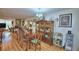 Open-concept dining room with hardwood floors and a large, ornate china cabinet at 200 El Camino Dr # 202, Winter Haven, FL 33884