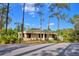 Street view of single-story home featuring mature trees and a well-maintained lawn at 200 El Camino Dr # 202, Winter Haven, FL 33884