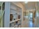 Bright hallway with built-in shelving and decorative accents, leading to a naturally lit entrance at 200 El Camino Dr # 202, Winter Haven, FL 33884