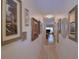 Hallway with artwork on walls and light wood flooring visible at the end at 200 El Camino Dr # 202, Winter Haven, FL 33884