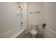 Bright white bathroom featuring a shower-tub combination with a tile backsplash at 2005 Carnostie Rd, Winter Haven, FL 33884