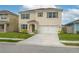 Charming two-story home featuring a well-manicured lawn, neutral stucco, attached garage and colorful green shutters at 2005 Carnostie Rd, Winter Haven, FL 33884