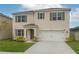 Charming two-story home featuring a well-manicured lawn, neutral stucco, attached garage and colorful green shutters at 2005 Carnostie Rd, Winter Haven, FL 33884