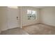 Sunlit living room featuring neutral paint, carpeted floors, and a view of the front yard at 2005 Carnostie Rd, Winter Haven, FL 33884