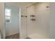 Modern shower with white tile and mounted shelving in a bathroom at 2005 Carnostie Rd, Winter Haven, FL 33884