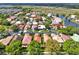 A high angle view of the neighborhood and pond, showcasing various residences with colorful roofing at 208 Lake Region S Blvd, Winter Haven, FL 33881