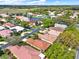 Aerial view of a neighborhood with several homes, lush greenery, and a lake at 208 Lake Region S Blvd, Winter Haven, FL 33881