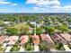 Aerial view of homes with tile roofs, showcasing the manicured lawns, landscaping, and a green space at 208 Lake Region S Blvd, Winter Haven, FL 33881