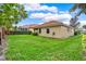 A view of the green grass backyard showcasing the exterior of the home at 208 Lake Region S Blvd, Winter Haven, FL 33881