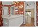 Spacious bathroom with double vanity, white cabinets, large mirror, and floral wall paper at 208 Lake Region S Blvd, Winter Haven, FL 33881
