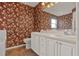 Bathroom featuring wallpaper, double sink vanity, decorative mirrors and lighting, and combination tub/shower at 208 Lake Region S Blvd, Winter Haven, FL 33881