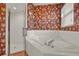 Bathroom with shower and soaking tub featuring red floral wallpaper, glass shower, and window at 208 Lake Region S Blvd, Winter Haven, FL 33881